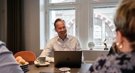 Juha Frey hymyilee neuvotteluhuoneessa
