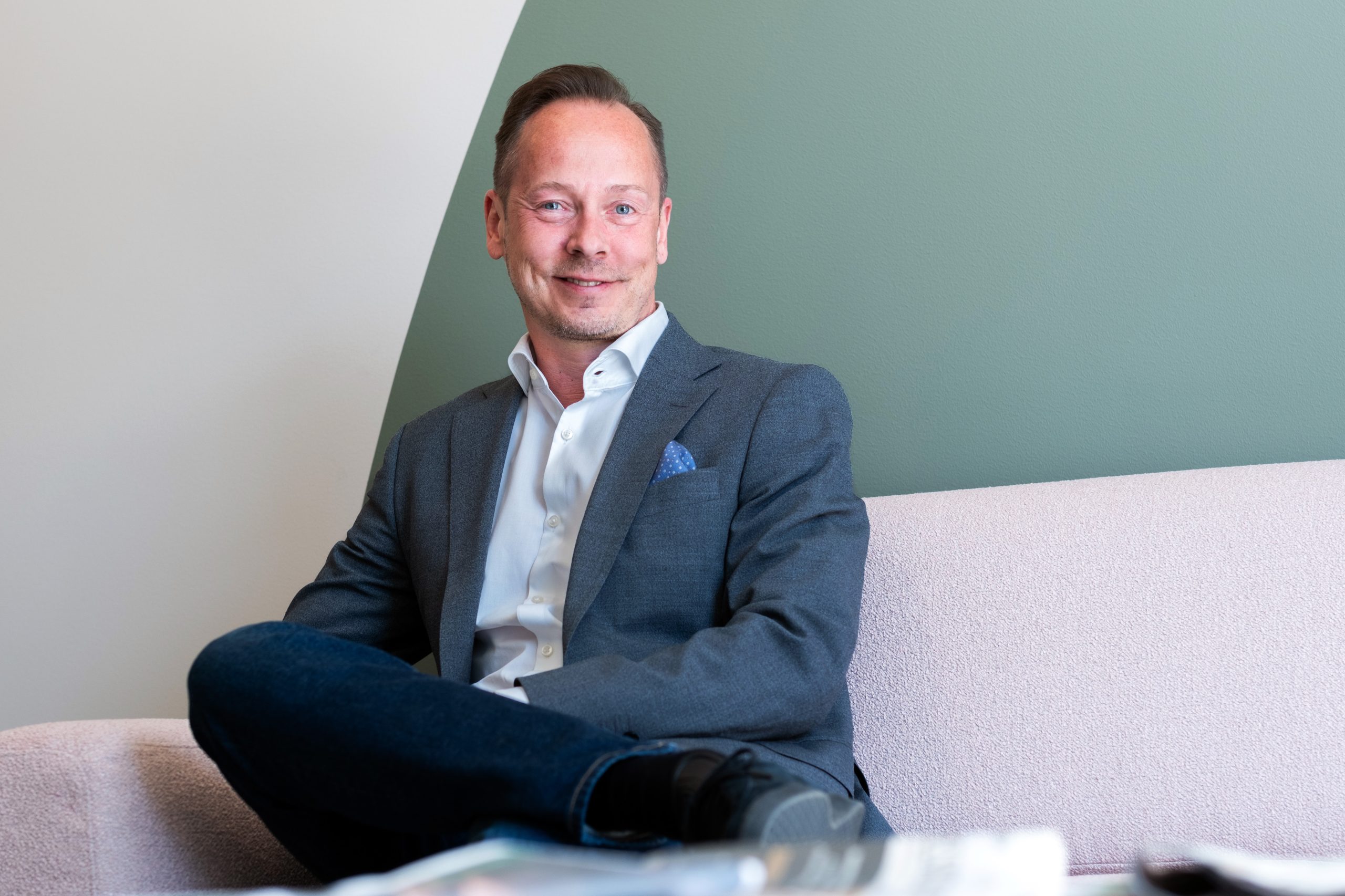 Netprofilen toimitusjohtaja Juha Frey istuu valoisassa toimistossa katsoen kameraan hymyillen.
